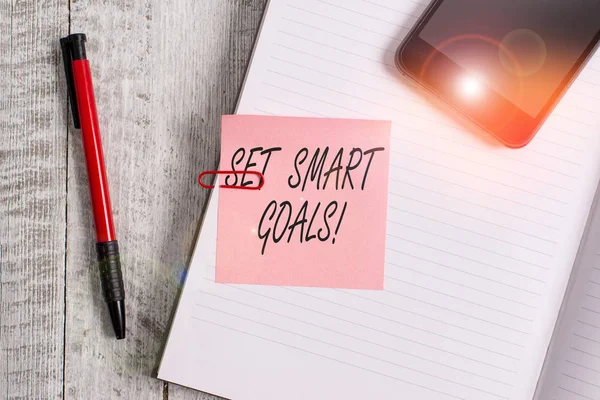Handwriting text writing Set Smart Goals. Concept meaning list to clarify your ideas focus efforts use time wisely Thick pages notebook stationary placed above classic look wooden backdrop.