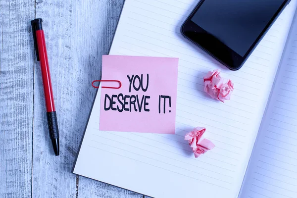 Text sign showing You Deserve It. Conceptual photo should have it because of their qualities or actions Thick pages notebook stationary placed above classic look wooden backdrop.