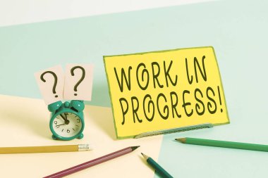 Çalışmanın İlerlediğini gösteren kavramsal el yazısı. İş fotoğrafı metni tamamlanmamış proje Pastel arkaplanının yanında Mini boyutunda alarmlı saat eklendi ya da geliştirildi.