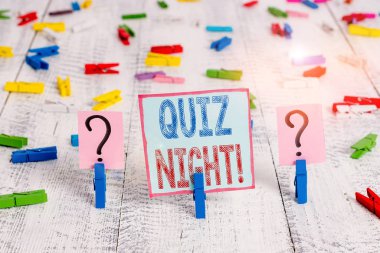 Quiz Night 'ı gösteren bir not yazıyorum. İş fotoğrafı gösterimi akşam test bilgisi yarışması. Tahta masaya raptiyeyle tutturulmuş kırılan kağıtlar arasında..
