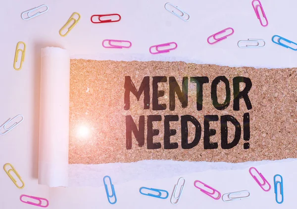 Word writing text Mentor Needed. Business concept for Employee training under senior assigned act as advisor Paper clip and torn cardboard placed above a wooden classic table backdrop.