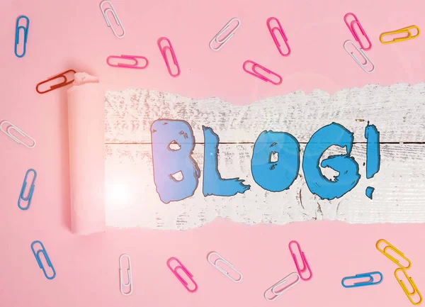 Conceptual hand writing showing Blog. Business photo showcasing regularly updated website web page run by individual or group Paper clip and torn cardboard on wood classic table backdrop.