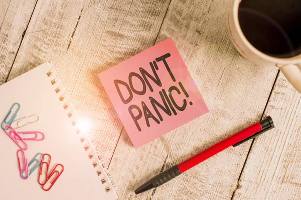 Escribiendo nota mostrando Don T Panic. Foto de negocios mostrando repentinamente se siente tan preocupado o asustado que no se puede comportar estacionario colocado junto a una taza de café negro por encima de la mesa de madera . — Foto de Stock