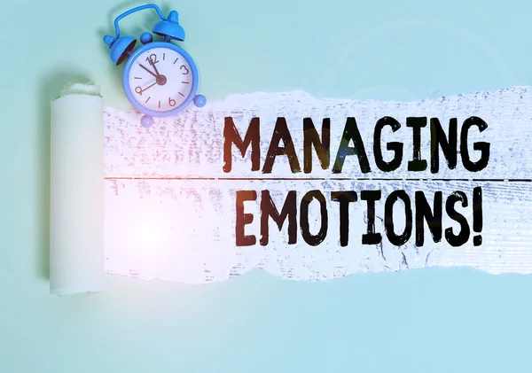 Escribir una nota mostrando Managing Emotions. La capacidad de mostrar fotos de negocios estar abierto a los sentimientos y modularlos en uno mismo Reloj despertador y cartón desgarrado en un fondo de mesa clásico de madera . — Foto de Stock