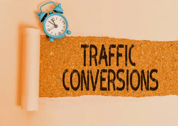 Writing note showing Traffic Conversions. Business photo showcasing visitor who has been converted into a client or customer Alarm clock and torn cardboard on a wooden classic table backdrop. — Stock Photo, Image