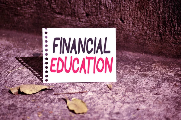 Handwriting text Financial Education. Concept meaning education and understanding of various financial areas Empty Spiral Bound Notebook Sheet Torn Off Folded in Half Dried Leaves.