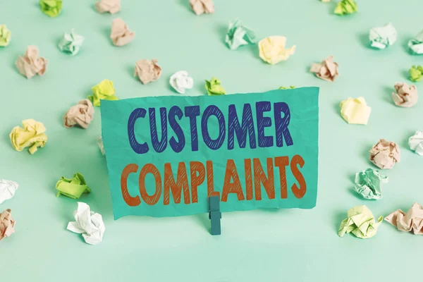 単語の書き込みテキスト顧客苦情。消費者の不満を表現するためのビジネスコンセプトは、代わりに色の砕けた紙空のリマインダー青の床の背景の服ピン. — ストック写真