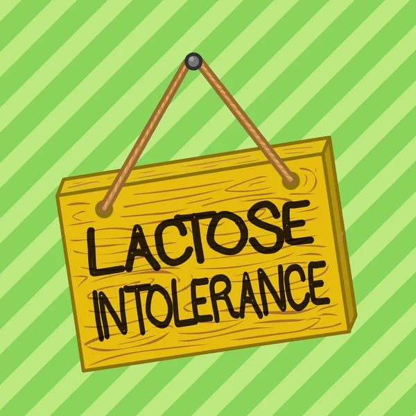 Text sign showing Lactose Intolerance. Conceptual photo digestive problem where body is unable to digest lactose Square rectangle unreal cartoon wood wooden hang down on the coloured wall.