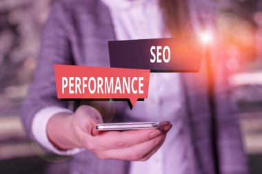 Seo Performans Analizi 'ni gösteren metin işareti. Kavramsal fotoğraf trafiğin miktarını ve kalitesini gri süitlerdeki kadının cep telefonuna yükseltir.