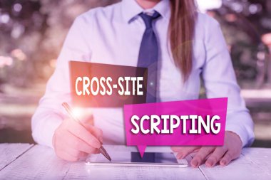 El yazısı Çapraz Site Betiği. Kavram, temel olarak internet uygulamasında bulunan güvenlik açığı anlamına geliyor. Masanın yanında oturan ve cep telefonu tutan kadın iş adamı..