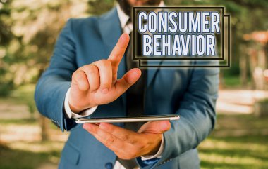 Tüketici Davranışını gösteren metin işareti. Özel müşterilerin mavi süitteki marka iş adamıyla nasıl etkileşime geçtiğine dair kavramsal fotoğraf çalışması dizüstü bilgisayarı elinde tutuyor..