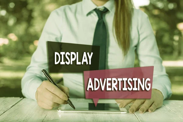 Handwriting text Display Advertising. Concept meaning online advertising that is typically a designed image Female business person sitting by table and holding mobile phone.
