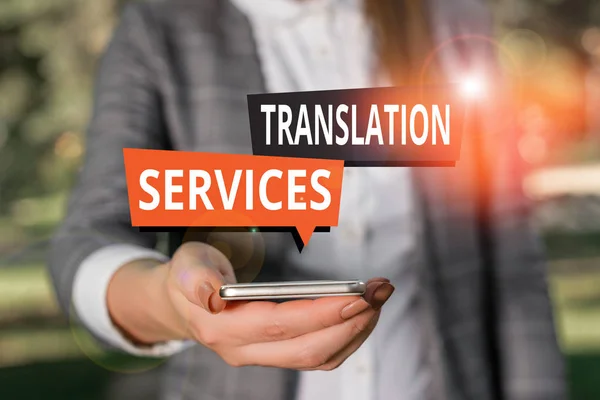 Text sign showing Translation Services. Conceptual photo organization that provide showing to translate speech Woman in grey suites holds mobile phone. — Stockfoto