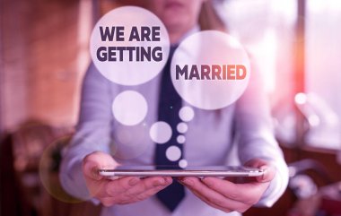 Kavramsal el yazısı evlendiğimizi gösteriyor. İş fotoğrafı metni. Nişan hazırlığı. Arka planda sevgi dolu bir çift var..