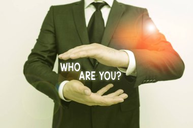 Handwriting text writing Who Are You Question. Concept meaning asking about someone identity or demonstratingal information Male human with beard wear formal working suit clothes raising one hand up.