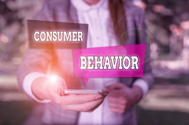 Tüketici Davranışını gösteren kavramsal el yazısı. Gri süitlerdeki kadın marka ile bireysel müşterilerin nasıl etkileşime geçtiğini gösteren iş fotoğrafı çalışması cep telefonu tutuyor.