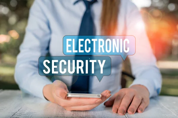 Word writing text Electronic Security. Business concept for electronic equipment that perform security operations Female business person sitting by table and holding mobile phone.