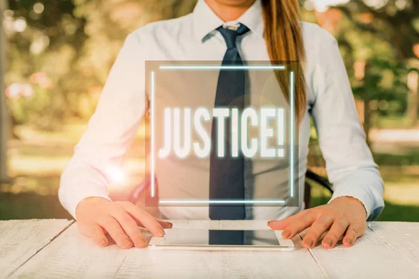 Sinal de texto mostrando Justiça. Foto conceitual ajuste imparcial de reivindicações conflitantes ou atribuições Feminino empresário sentado à mesa e segurando telefone celular . — Fotografia de Stock