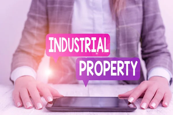 Tekst schrijven Industrial Property. Bedrijfsconcept voor de immateriële eigendom van een handelsmerk of octrooi Zakelijke vrouw met mobiele telefoon op tafel. — Stockfoto