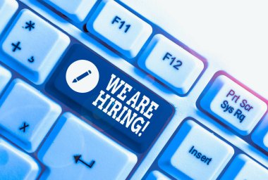 Kavramsal el yazısı işe aldığımızı gösteriyor. İş fotoğrafı metni geçenlerde birini işe aldınız ya da özel bir iş yapması için birine para verdiniz beyaz arkaplanının üzerinde nota kağıdı olan beyaz pc klavye.