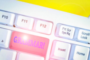 Dilbilgisi gösteren not yazma. Tüm sistem yapısı dil sözdizimi ve morfoloji beyaz arka plan üzerinde not kağıdı ile beyaz pc klavye vitrine İş fotoğraf.