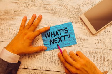 SMS işareti sıradaki soruyu gösteriyor. Yaklaşan eylemi ya da davranışını gösteren kavramsal fotoğraf yazma ekipmanı ve modern akıllı telefon cihazının yanında el yazısı kağıdı tutuyor..