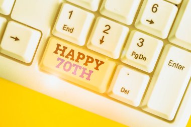 70. yaş gününü gösteren kavramsal el yazısı. İş fotoğrafı metni, 70. Yıl Beyaz PC klavyesini beyaz arkaplanın üzerinde not kağıdıyla işaretlemek için neşeli bir olay vesilesi.