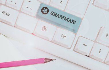 Dilbilgisi'ni gösteren metin işareti. Kavramsal fotoğraf tüm sistem yapısı dil sözdizimi ve morfoloji beyaz arka plan anahtar kopyalama alanı üzerinde boş not kağıdı ile beyaz pc klavye.
