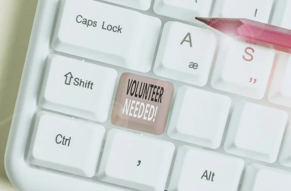 Writing note showing Volunteer Needed. Business photo showcasing asking demonstrating to work for organization without being paid White pc keyboard with note paper above the white background. — Stock Photo, Image