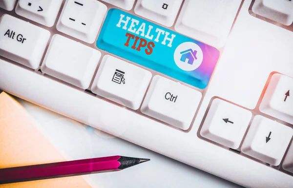Handwriting text Health Tips. Concept meaning advice or information given to be helpful in being healthy White pc keyboard with empty note paper above white background key copy space.