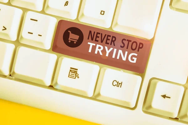 Writing note showing Never Stop Trying. Business photo showcasing Do not give up Continue to Try Again Keep on Doing White pc keyboard with note paper above the white background.