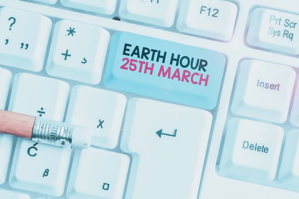 地球時間3月25日を示すメモを書く。惑星へのシンボルコミットメントを示すビジネス写真組織化された世界基金白の背景の上にノートパソコンのキーボード. — ストック写真