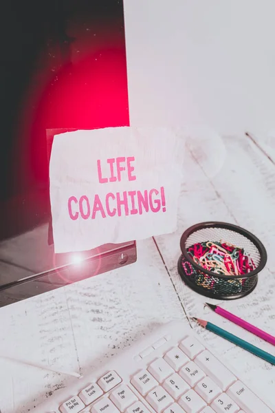 Text sign showing Life Coaching. Conceptual photo demonstrating employed to help showing attain their goals in career Note paper taped to black computer screen near keyboard and stationary.