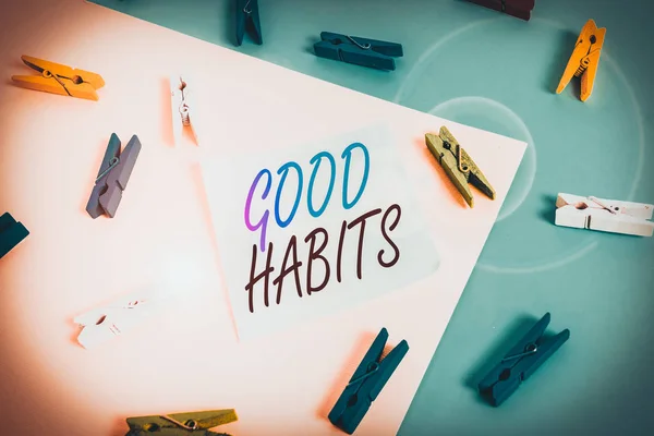 Text sign showing Good Habits. Conceptual photo behaviour that is beneficial to one s is physical or mental health Colored clothespin paper empty reminder yellow blue floor background office.
