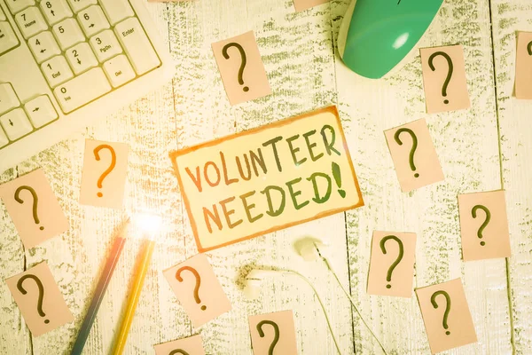 Handwriting text writing Volunteer Needed. Concept meaning asking demonstrating to work for organization without being paid Writing tools, computer stuff and scribbled paper on top of wooden table. — Stock Photo, Image