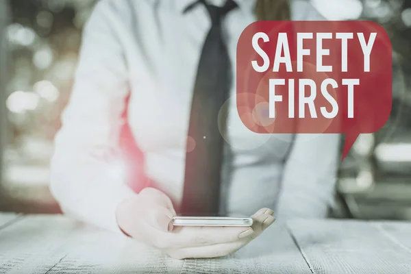Najpierw notatka o bezpieczeństwie. Pokazywanie zdjęć biznesowych zwykło mawiać, że najważniejszą rzeczą jest być bezpiecznym Kobieta biznesu osoba siedzi przy stole i trzyma telefon komórkowy. — Zdjęcie stockowe
