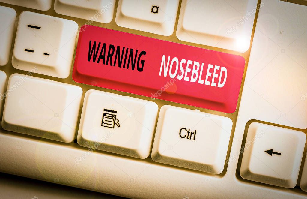Conceptual hand writing showing Warning Nosebleed. Business photo showcasing caution on bleeding from the blood vessels in the nose White pc keyboard with note paper above the white background.