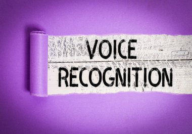 Ses Tanıma 'yı gösteren bir not yazıyorum. Bir bilgisayar sisteminin ses ya da seslerle kontrol edilmesi için kullanılan bir iş konsepti. Karton, ahşap klasik bir masanın üzerine yerleştirilmiş.