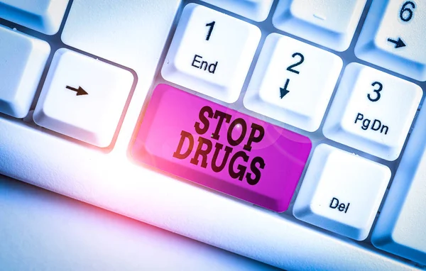 Texto escrito por palavra Stop Drugs. Conceito de negócio para acabar com a dependência de substâncias como heroína ou cocaína Teclado de PC branco com papel de nota vazio acima do espaço de cópia da chave de fundo branco . — Fotografia de Stock