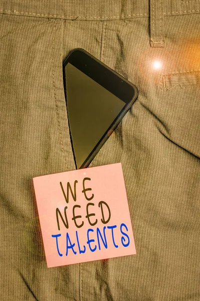 Handwriting text We Need Talents. Conceptual photo seeking for creative recruiters to join company or team Smartphone device inside formal work trousers front pocket near note paper