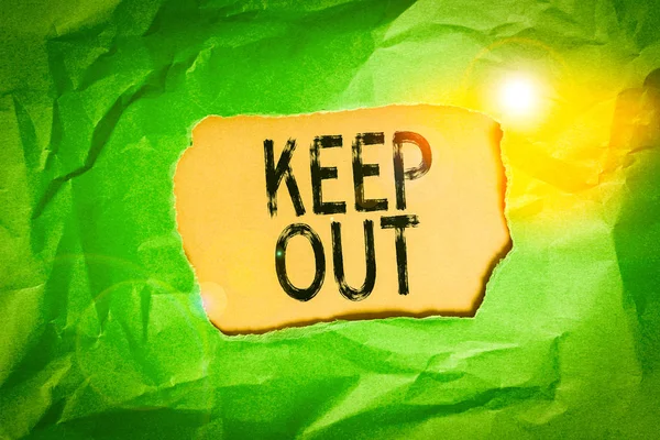 Handwriting text Keep Out. Concept meaning to stop someone or something from going into a place Danger sign Green crumpled ripped colored paper sheet centre torn colorful background.