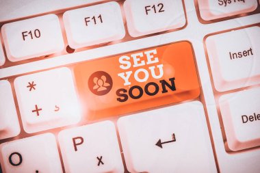 Kavramsal el yazısı yakında görüşürüz diyor. Biriyle vedalaşmak ve tekrar buluşmaya gitmek için kullanılan iş fotoğrafı metni beyaz arkaplanın üzerinde nota kağıdı ile birlikte.