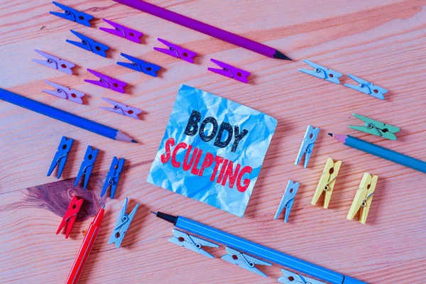 Word writing text Body Sculpting. Business concept for activity of increasing the body s is visible muscle tone Colored clothespin papers empty reminder wooden floor background office.