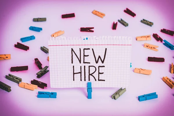 Writing note showing New Hire. Business photo showcasing someone who has not previously been employed by the organization Colored clothespin papers empty reminder white floor background office.