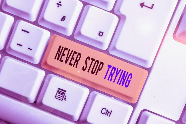 Text sign showing Never Stop Trying. Conceptual photo Do not give up Continue to Try Again Keep on Doing White pc keyboard with empty note paper above white background key copy space.