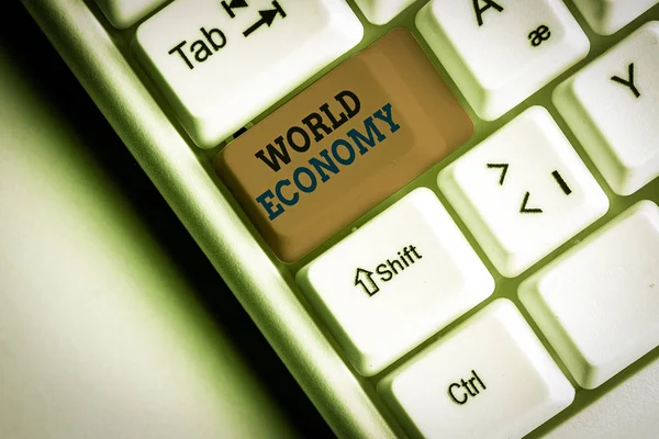 Wortschreibtext Weltwirtschaft. Geschäftskonzept für globale internationale Märkte Handel Geldbörse weiße PC-Tastatur mit leerem Notizpapier über weißem Hintergrund Schlüssel Kopierraum. — Stockfoto