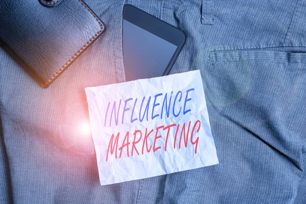Text sign showing Influence Marketing. Business photo text Using key leaders to drive a brand s is message to market Smartphone device inside trousers front pocket with wallet and note paper