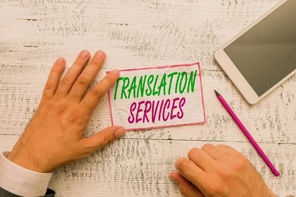 Conceptual hand writing showing Translation Services. Concept meaning organization that provide showing to translate speech Hand hold note paper near writing equipment and smartphone