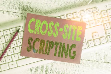 Handwriting text writing Cross Site Scripting. Conceptual photo Security vulnerability mainly found in web application White keyboard office supplies empty rectangle shaped paper reminder wood