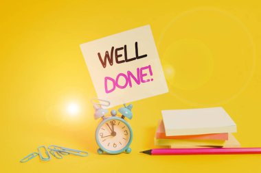 Conceptual hand writing showing Well Done. Concept meaning used praising demonstrating or group for something have done good way Alarm clock pencil clips note stacked notepads colored background